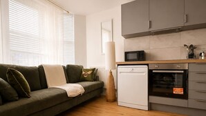 A modern kitchen with a built-in oven, a microwave, and a dishwasher. - Perfect Booking Bright 2 Bed Maisonette in Bath (Bath)