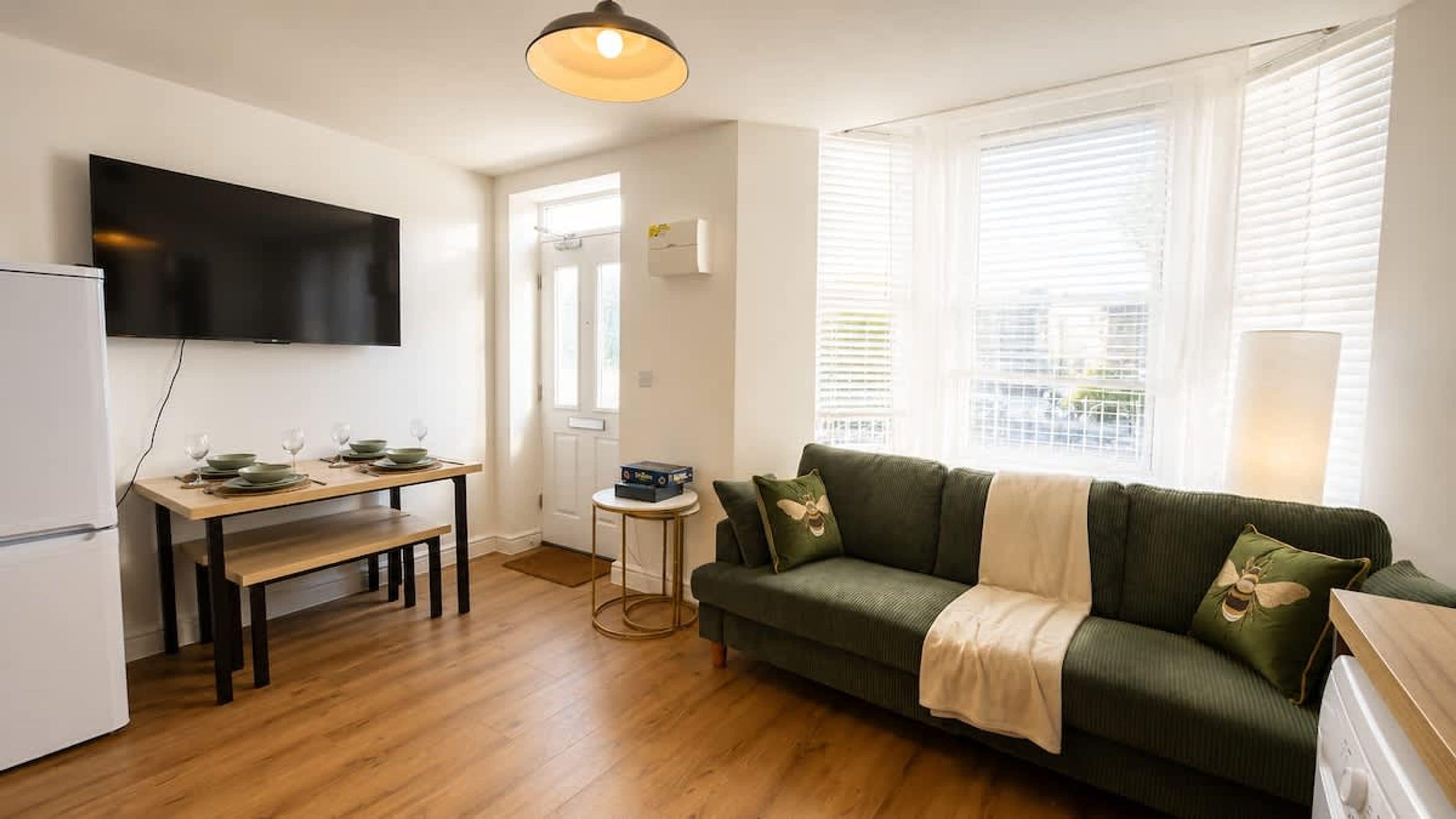 A compact living space with a dining area, a sofa, and a television.