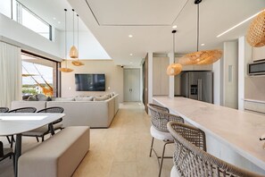A modern kitchen with a large island, built-in appliances, and pendant lighting. - Modern 4 Bedroom Villa With Tropical Vibes in Baru (Cartagena)