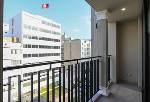 Ein Balkon mit Blick auf eine Skyline, darunter ein Gebäude mit einer Flagge.