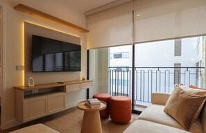 A modern living room with a flat-screen TV, a wooden console table, a sofa, and a small round table with a book. - w Designer 2BR Stay w Balcony in Miraflores (Lima)