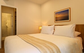 A hotel room with a bed, a nightstand, a wall-mounted lamp, and a painting above the bed. - w Designer 2BR Stay w Balcony in Miraflores (Lima)