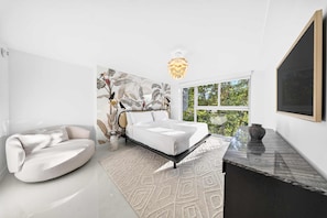 A modern bedroom with a bed, a sofa, a large window, and a unique wall art piece. - Chic Bay Harbor 3BR Rooftop Pool Free Parking (Bay Harbor Islands)