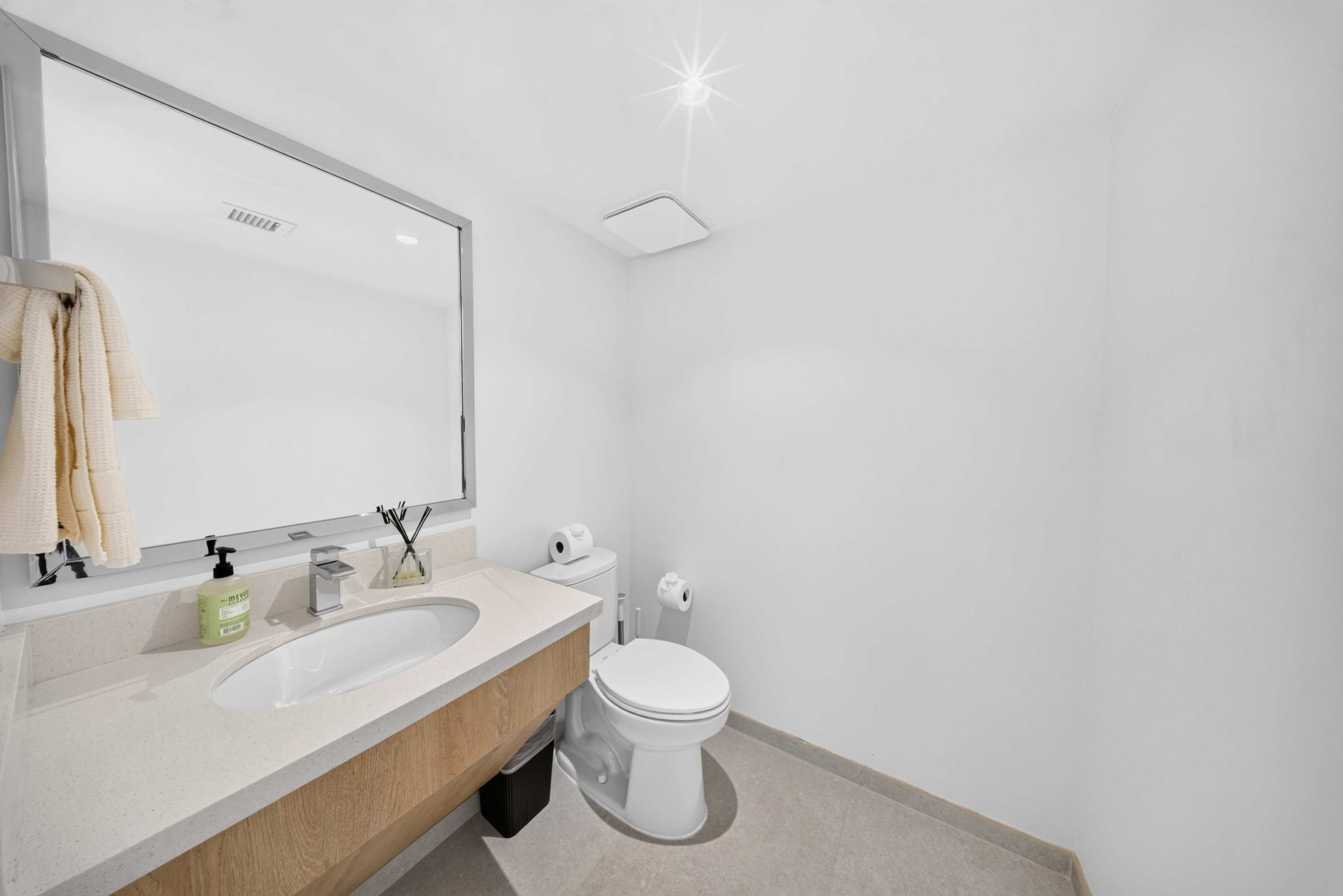 Un baño moderno con lavamanos doble, inodoro y un espejo grande.