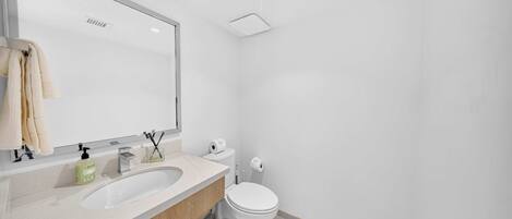 Un baño moderno con lavamanos doble, inodoro y un espejo grande.