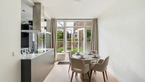 A modern kitchen with a dining area, large windows, and a view of the outside. - Urban Oasis With Garden in Rotterdam (Rotterdam)