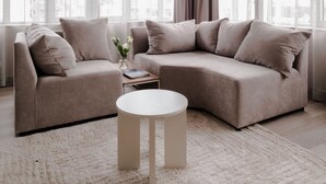 A modern living room with a sectional sofa, a round coffee table, and large windows with sheer curtains. - 2BR Penthouse Rotterdam City Centre (Rotterdam)