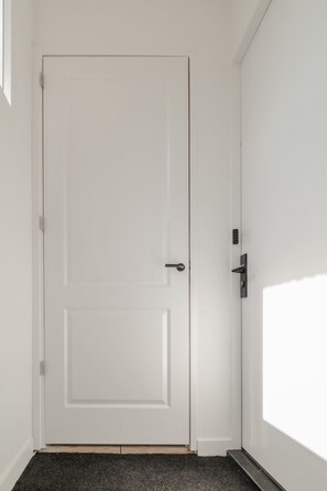 Una porta bianca con una maniglia semplice e una serratura.