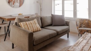 Uma sala de estar moderna com um sofá, mesa de centro e um quadro na parede.