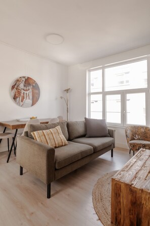 Ein modernes Wohnzimmer mit Sofa, Couchtisch und einem Gemälde an der Wand.