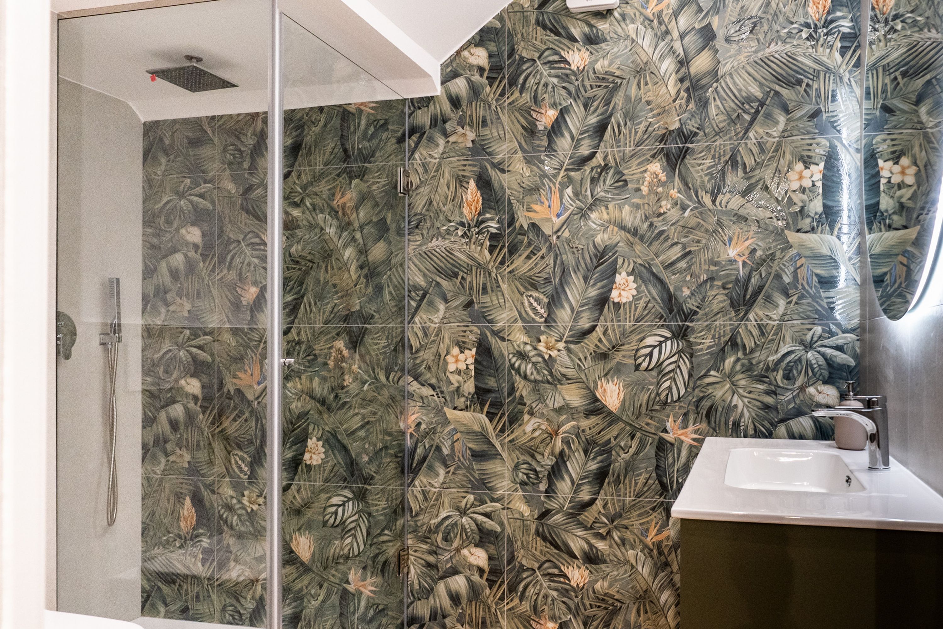A bathroom with a shower, a sink, and a mirror.