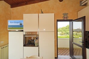 A kitchen with a built-in oven, a refrigerator, and a clock on the wall. - Raffa Holiday in Raffa (Puegnago del Garda)