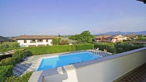 Et boligområde med swimmingpool, omgivet af grønt og huse.