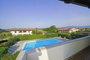 A residential area with a swimming pool, surrounded by greenery and houses. - Raffa Holiday in Raffa (Puegnago del Garda)