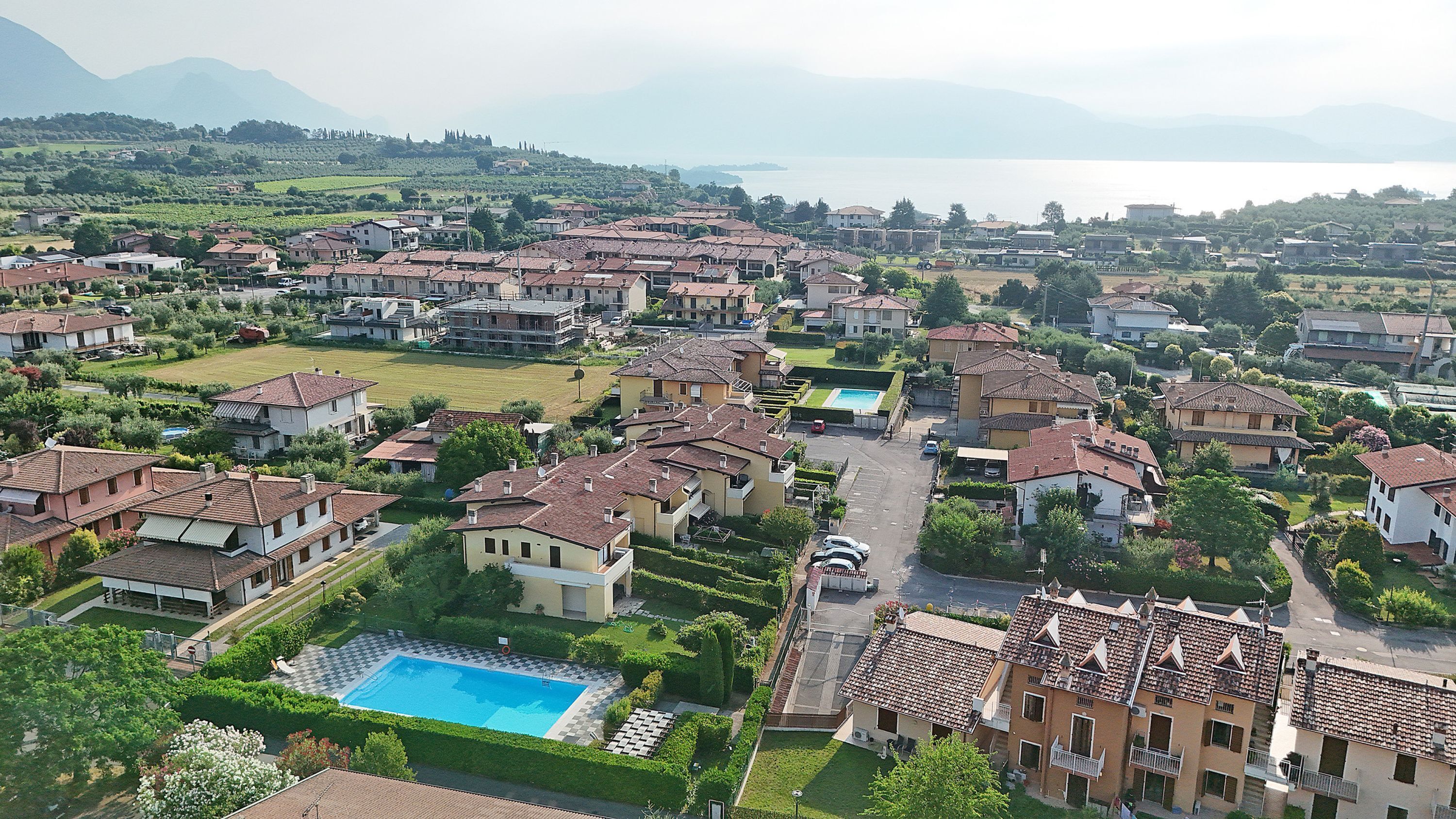 Um bairro residencial com várias casas, uma piscina e vista para o mar.