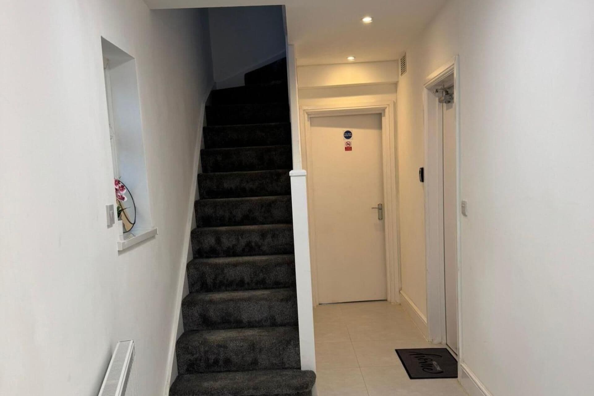 A staircase leading to a door with a doormat.