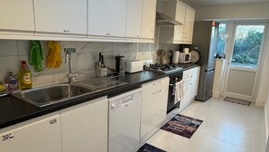 Una cocina moderna con armarios blancos, encimera negra y tragaluz.