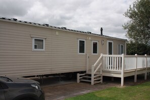 A mobile home with a front porch and a car parked in front. - 6 Berth Caravan Butlins Skegness Pet Friendly (Skegness)