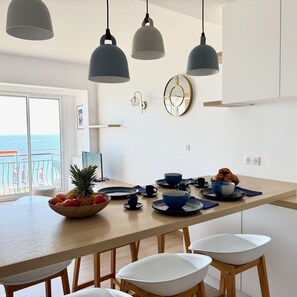 A modern kitchen with a central island, pendant lights, and a view of the sea. - Face mer à La Baule : Evobaule (La Baule-Escoublac)