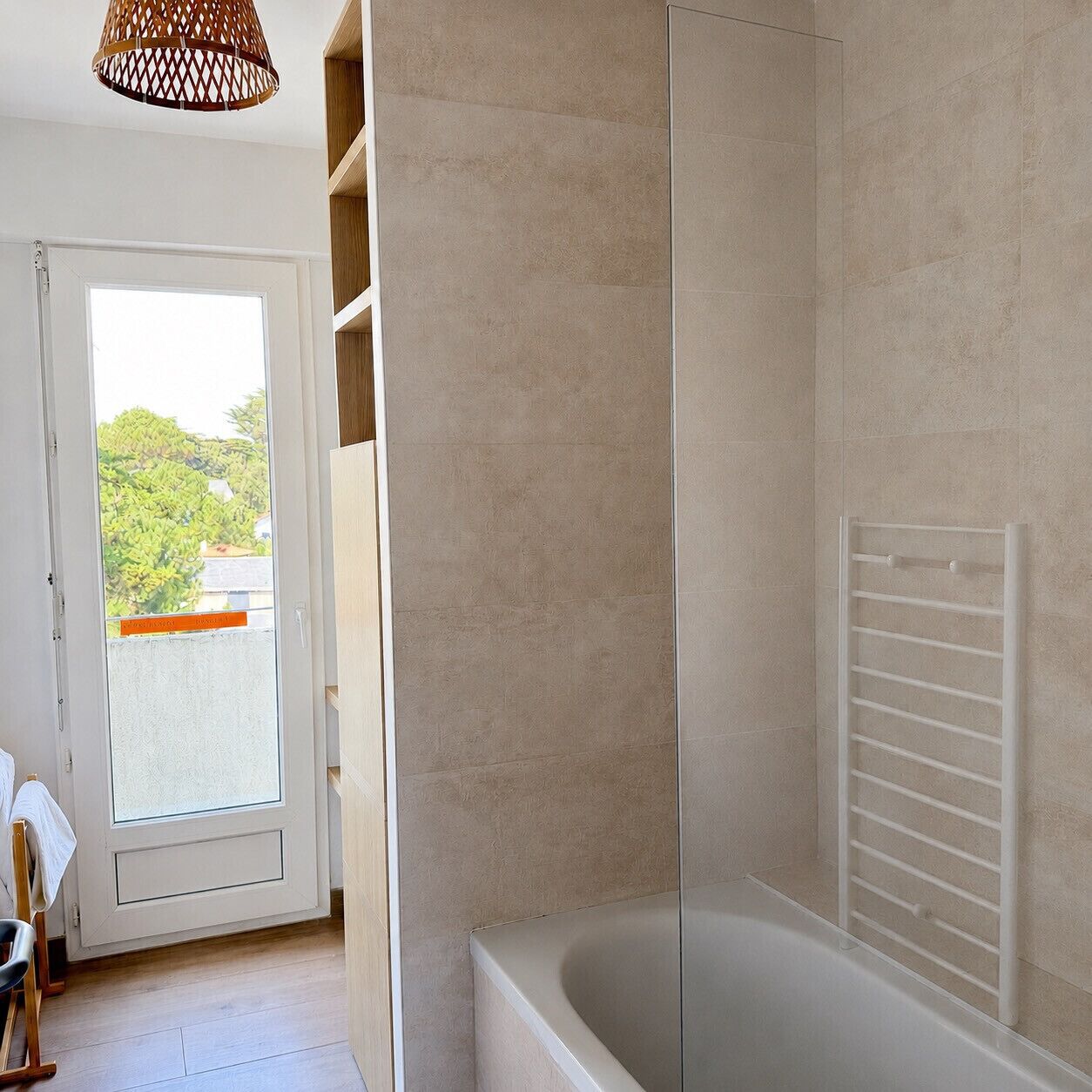 A bathroom with a bathtub, a shower area, and a white towel rack.