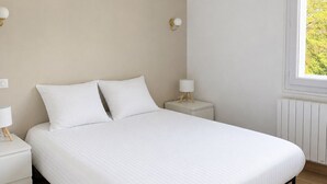 A bedroom with a bed, two bedside tables, and a window. - Face mer à La Baule : Evobaule (La Baule-Escoublac)