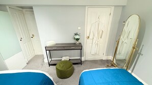 A bedroom with two beds, a desk, a mirror, and a wardrobe. - Prime City of London Accommodation (London)
