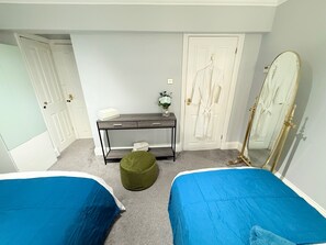 A bedroom with two beds, a desk, a mirror, and a wardrobe. - Prime City of London Accommodation (London)
