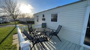 A mobile home with a deck, outdoor furniture, and a clear sky. - 8 Berth Caravan Butlins Skegness (Skegness)
