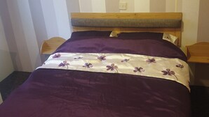 Ein Schlafzimmer mit einem Bett, einem Kopfteil, einem Wandbild und einem Nachttisch.