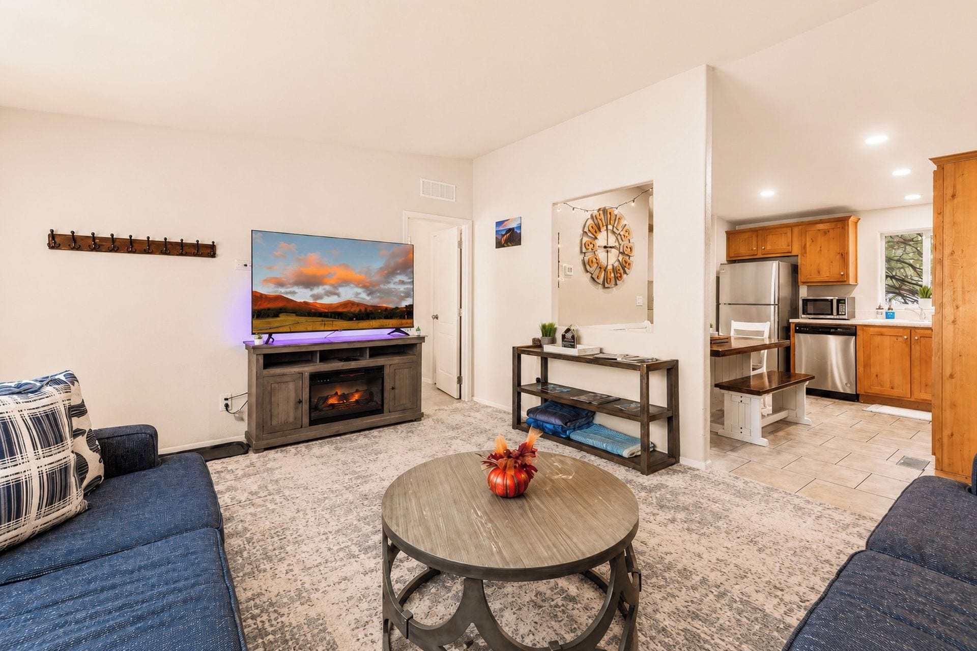 A living room with a flat-screen TV, a fireplace, a round coffee table, and a sofa.
