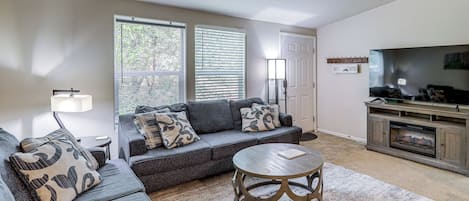 A living room with a sectional sofa, a coffee table, and a flat-screen TV.