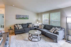 A living room with a sectional sofa, a round coffee table, and a painting on the wall. - Flagstaff Getaway 10 Mi to DT: Mini Golf, Fire Pit (Flagstaff)