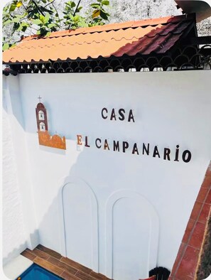 A sign with 'CASA EL CAMPANARIO' and a bell tower illustration.