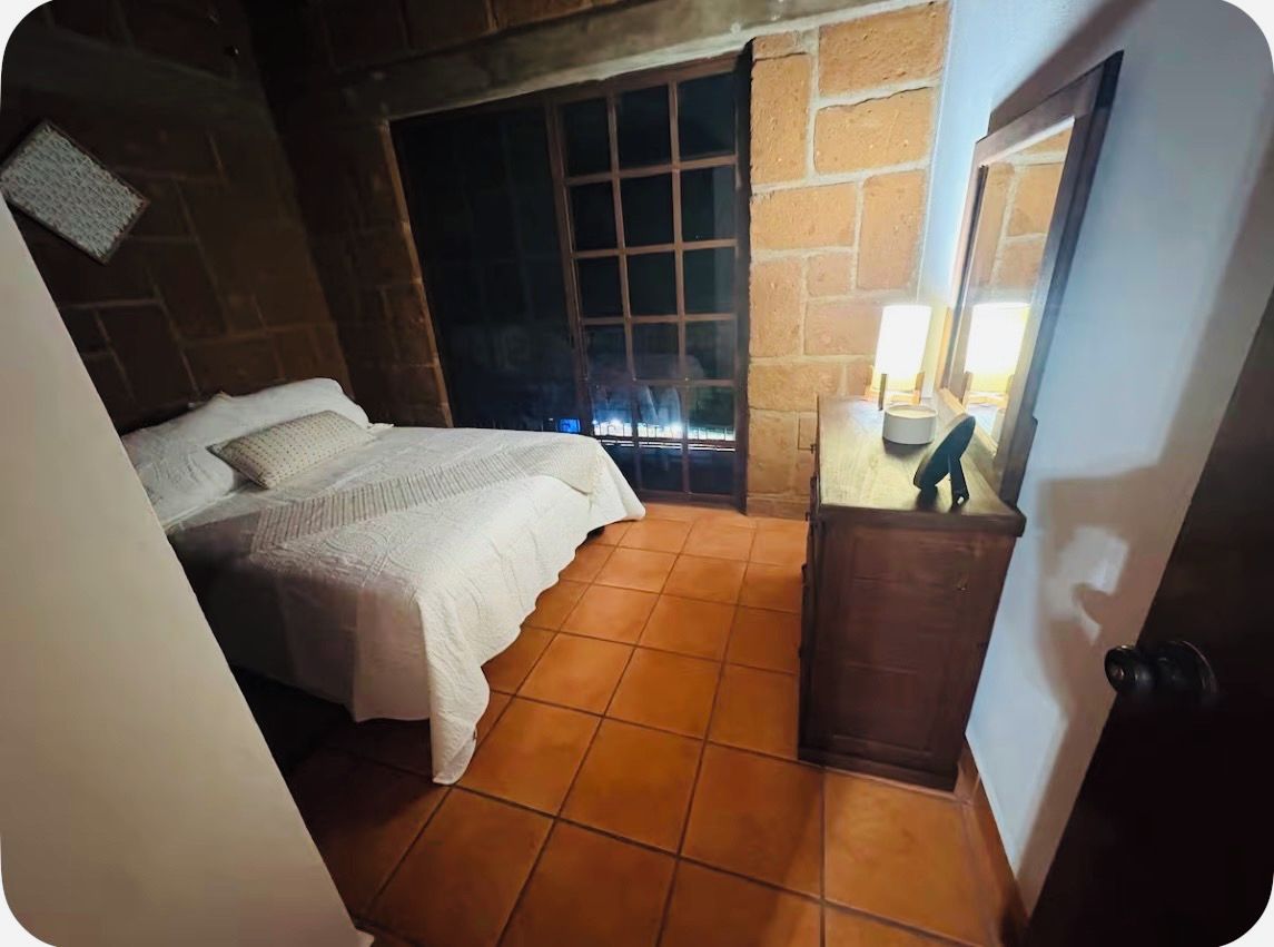 Un dormitorio con cama, ventana y puerta.