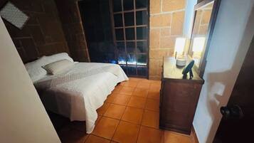 Un dormitorio con cama, ventana y puerta.