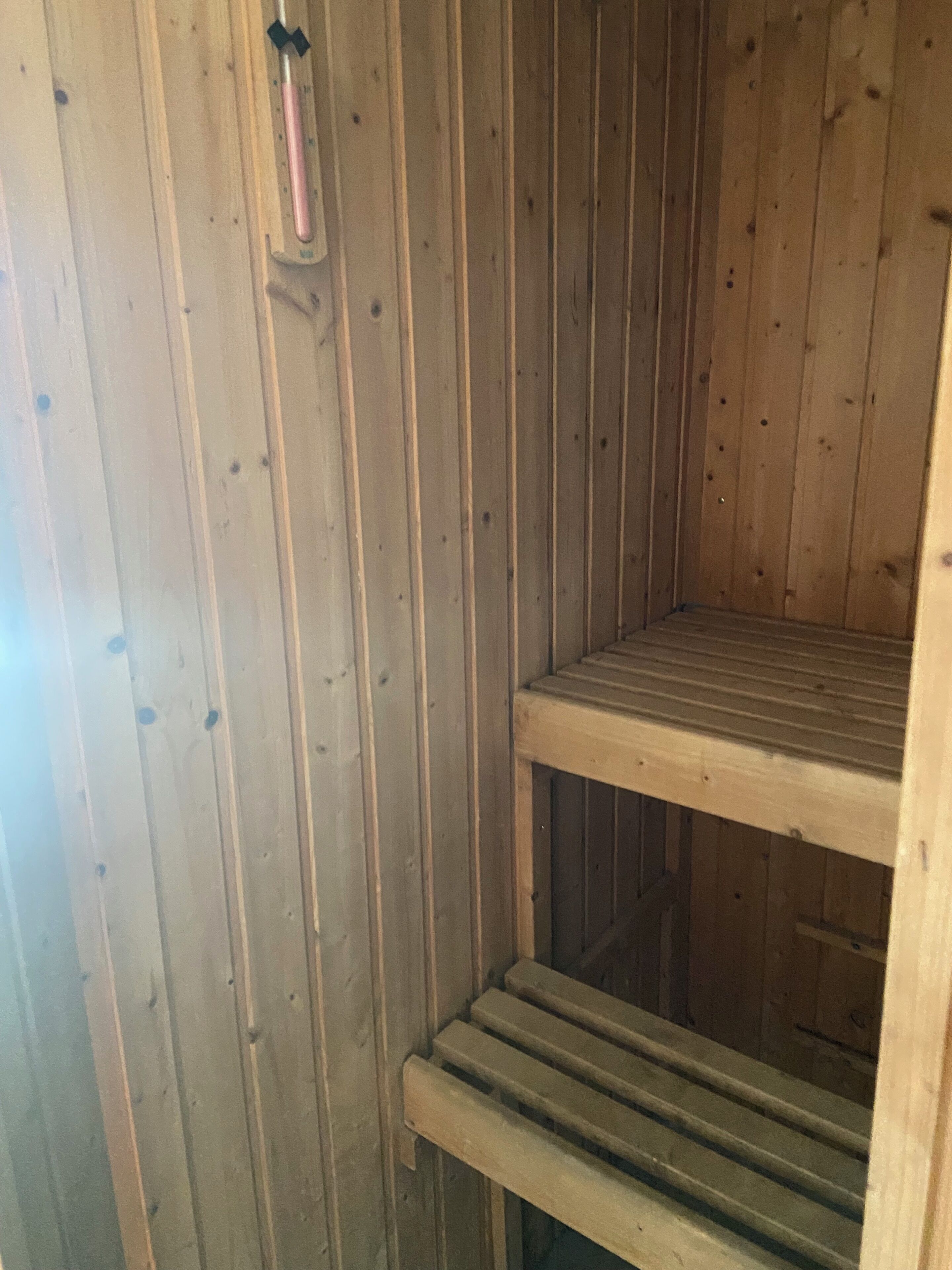 Un intérieur en bois, avec une étagère en métal et une rambarde en métal.