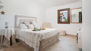 A bedroom with a bed, bedside table, lamp, and a window with a view. - Villa Sa Xabola - Three Bedroom Villa, Sleeps 6 (Can Tabou)