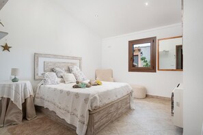 A bedroom with a bed, bedside table, lamp, and a window with a view. - Villa Sa Xabola - Three Bedroom Villa, Sleeps 6 (Can Tabou)