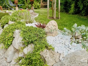 A garden with various plants and rocks. - Loft with lily pond and mountain pastures (Hausham)