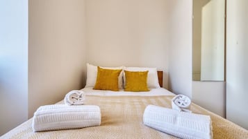 Ein Hotelzimmer mit einem Bett, zwei Kissen und zwei Handtüchern.