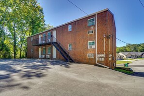 A two-story brick building with a central staircase, a covered outdoor area, and a parking lot.