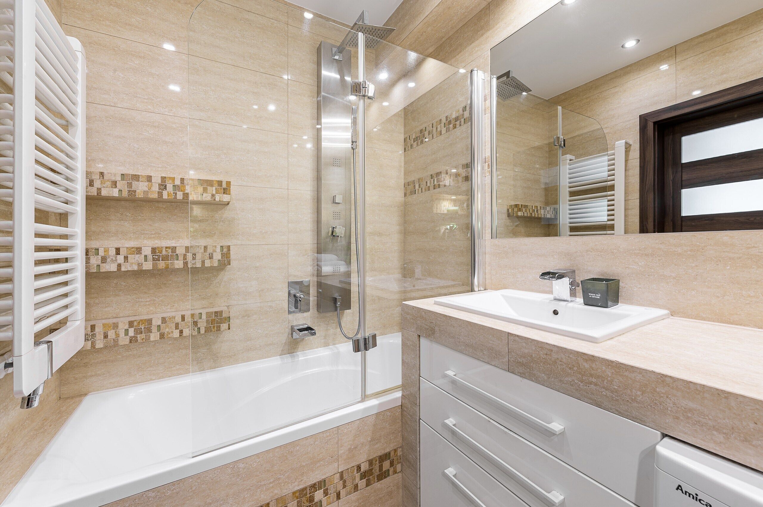 Un bagno moderno con una vasca, una doccia e un lavabo con mobile contenitore.