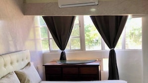 Una camera da letto con un letto, una scrivania e un condizionatore d'aria.