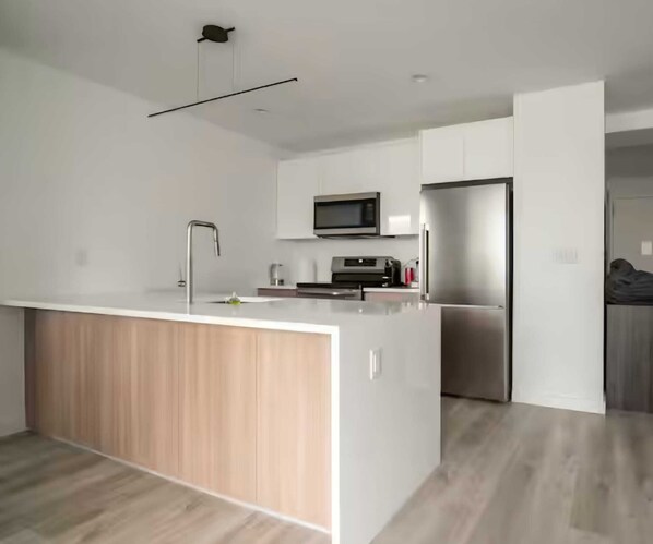 A modern kitchen with a central island, stainless steel appliances, and a minimalist design.