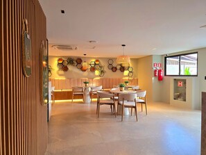 Eine Hotelhalle mit Sitzgelegenheiten, einem Empfangsbereich und einem großen Fenster.