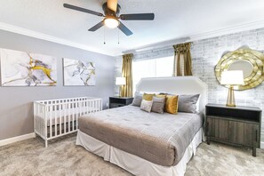 A bedroom with a bed, a crib, a ceiling fan, artwork, a window with curtains, and a mirror. - Special Offer! Cozy Townhome/Private Pool/Themed BRs 3011PL (Kissimmee)