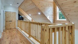 A wooden interior with a sloped ceiling, a wooden railing, and a door. - Helen Family Home w/ Innsbruck Resort Perks! (Helen)