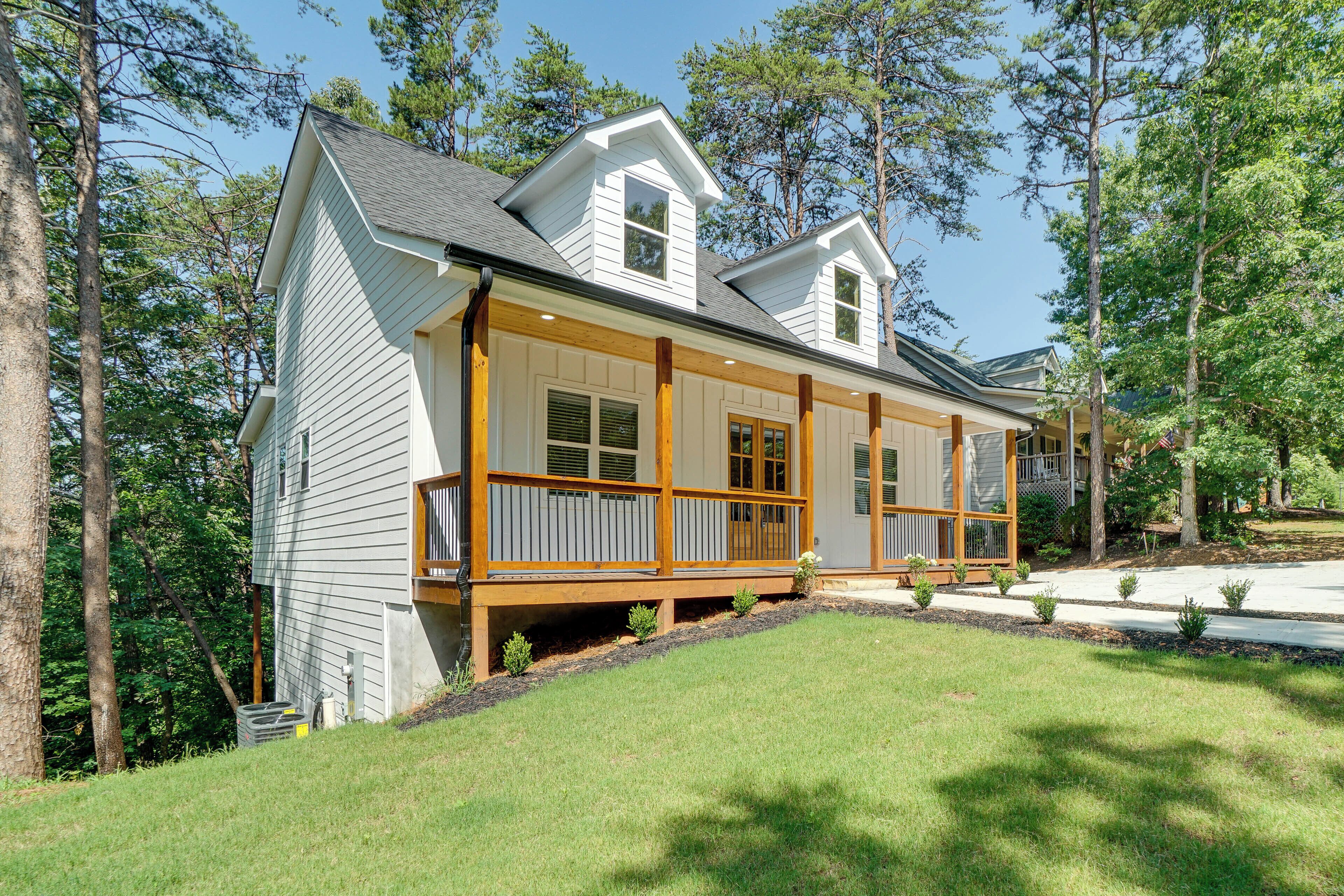 A two-story house with a covered porch and a small front yard.
