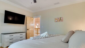 A bedroom with a large bed, a TV mounted on the wall, a wooden wardrobe, and a painting on the wall. - Helen Family Home w/ Innsbruck Resort Perks! (Helen)