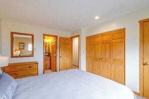 Un dormitorio con cama, armario de madera, cómoda y espejo.